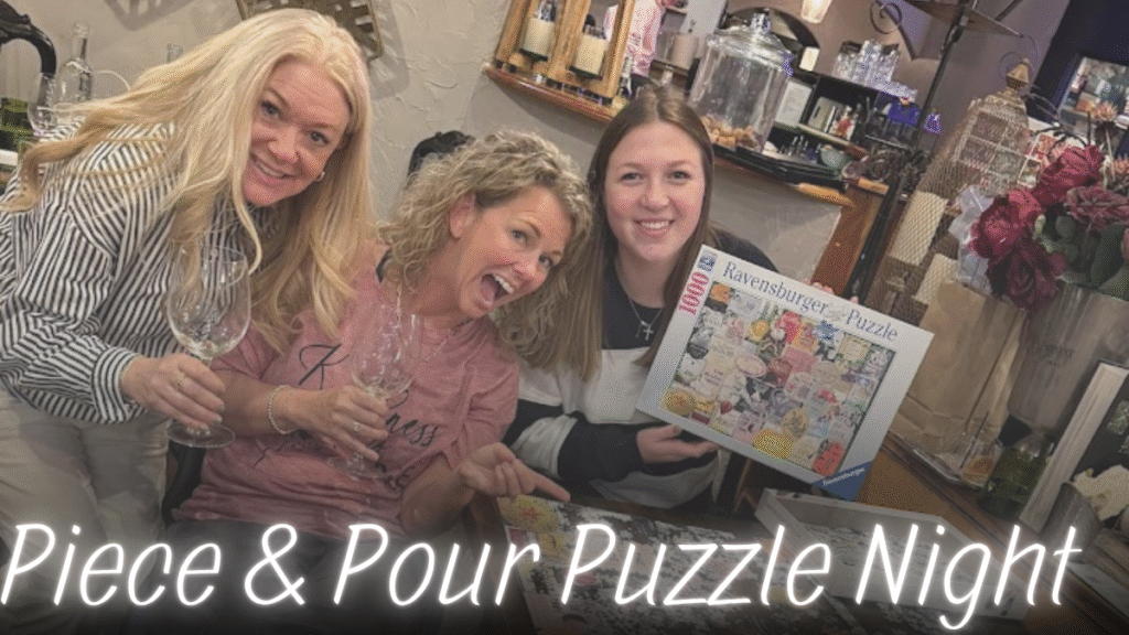 Three friends smiling while working on a puzzle, one holding up the puzzle box, all gathered around a table.